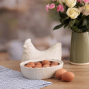Open ceramic hen egg storage dish filled with brown eggs, farmhouse style kitchen decor with flowers and striped cloth on wooden table