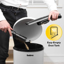 Person emptying the Beldray vacuum’s dust container into a bin, with a graphic indicating a 100 ml easy-empty dust tank feature.