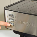 Close-up of a person pressing a button on a Salter espresso machine with a cup positioned underneath.