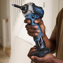 Handheld cordless impact driver with extended bit, held in one hand, showing ergonomic grip and battery base, suitable for DIY or construction use.