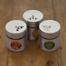 Three stainless steel spice jars with different shaker hole settings on top.