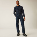 Full-body view of man in blue technical trousers and long-sleeve top, styled with durable walking boots