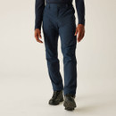 Front view of navy performance trousers with articulated knees and zip pockets, paired with outdoor boots