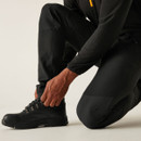 Close-up of black hiking trousers with secure zip cargo pocket and durable water-resistant fabric