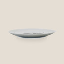 Side view of a white ceramic plate with a subtle Highland cow design visible inside.