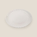 White ceramic plate with a scalloped, fluted rim on a plain background.