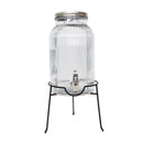 Ribbed glass drinks dispenser with silver lid placed on a black metal stand, front view.
