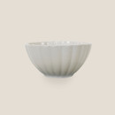 Small cream fluted stoneware bowl, side profile.
