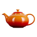 Rear angle of orange ceramic teapot showing rounded body and handle detail