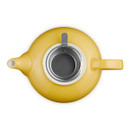 Top view of yellow teapot with lid removed, revealing stainless steel infuser inside