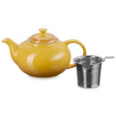 Yellow ceramic teapot with lid and removable stainless steel infuser on a plain background