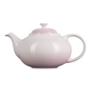 Side profile of pale pink ceramic teapot with rounded body and curved spout