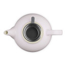 Top view of pale pink teapot with lid removed, revealing stainless steel infuser inside