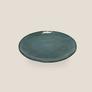 Green glazed stoneware dinner plate viewed from above on a light background.