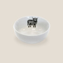 White porcelain bowl with Highland cow illustration inside, shown on a light background.