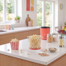 Freshly made popcorn served in tubs beside the Giles & Posner popcorn maker, highlighting easy snack preparation for movie nights.