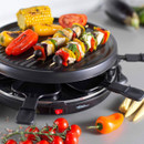 Close-up of vegetable kebabs and corn cooking on the non-stick grill plate of the Giles & Posner raclette grill.