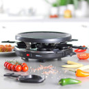Giles & Posner electric raclette grill on a kitchen worktop with ingredients and serving utensils, ready for tabletop cooking.