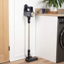 Beldray AiroEase cordless vacuum cleaner stored upright against a wall, featuring a slim stick design and motorised floor head.
