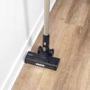 Beldray AiroEase cordless vacuum cleaning along skirting boards on a hard floor, with LED floor head lights for improved visibility.