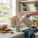 Salter Malmo kettle pouring hot water into a mug on a breakfast table, alongside matching toaster and kitchen accessories.