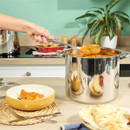 Large Russell Hobbs stainless steel stockpot filled with curry, being served with a ladle in a modern kitchen.