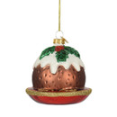 Hand-painted glass Christmas pudding ornament with white icing, green holly leaves and red berry detail, displayed on a red plate with gold glitter trim and hanging loop.