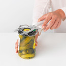 Brabantia Tasty+ universal opener being used to twist open a metal jar lid, providing extra grip and leverage.