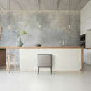 Brabantia Bo Touch Bin Hi recycling bin in Matt Steel Mineral Infinite Grey positioned in a modern kitchen with a concrete-effect wall and minimalist décor.