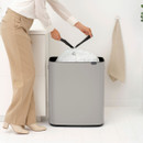 User removing a full bin liner from the Brabantia Touch Bin 60L, highlighting convenient waste bag replacement.