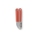 Brabantia Tasty+ garlic press with coral handles and grey body, shown open to display the pressing chamber.