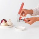 Person opening the Brabantia Tasty+ garlic press to remove pressed garlic residue for quick and easy cleaning.