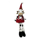 Black and white spotted cow Christmas decoration with dangling legs, wearing a red skirt, striped scarf and tall Santa hat, ideal for shelves, mantelpieces and festive home décor.