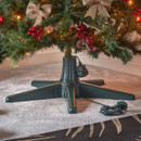 Green Christmas tree stand with integrated power socket, supporting a decorated artificial Christmas tree and featuring a UK plug connection for convenient festive lighting setup.