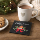 Festive slate coaster featuring a robin illustration with holly leaves, a red ribbon and the Welsh greeting “Nadolig Llawen”, displayed beside a mug of hot chocolate and Christmas decorations.