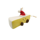 Angled view of a ceramic brie cheese Christmas decoration with a smiling face, Santa hat, and hanging twine.