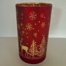Red glass candle holder with gold winter woodland design, featuring deer, fir trees and snowflake detailing for festive table or mantel displays.