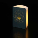 Illuminated Hogwarts Astronomy Spell Book Light standing upright with glowing page edges and an embossed Hogwarts astronomy-themed cover, displayed on a black background.