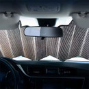 Reflective folding sun shade installed across a car windscreen, reducing heat build-up and protecting the vehicle interior from direct sunlight.