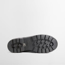 Bottom view of a black Barbour ankle wellington boot showing a chunky lug sole with deep tread and Barbour branding.