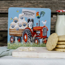 Farmhouse Biscuits gift tin featuring a vintage red tractor with sheep in a trailer, a sheepdog, rooster and hen illustration, containing 280g of luxury biscuits.