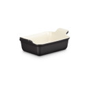 Three-quarter front view of the rectangular stoneware baking dish showcasing the satin black exterior, cream interior and ergonomic handles.