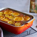 Rectangular stoneware baking dish in a Volcanic finish, shown fresh from the oven with a citrus-topped baked dessert, highlighting its presentation and serving versatility.