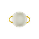 Top-down view of the Le Creuset Nectar stoneware mini round casserole dish with the lid removed, showing the cream-coloured interior.