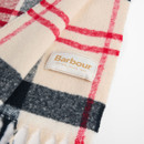 Close-up of the Barbour Deanna cranberry tartan scarf showing the woven Barbour logo label, soft brushed fabric and heritage tartan pattern.