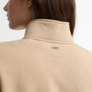 Close-up rear view of the Barbour women's beige quarter zip sweatshirt showing the high funnel neck and Barbour branded metal tab.