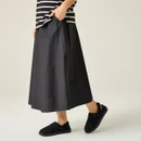 Black adjustable slingback mule slippers styled with a black midi skirt and striped top for a relaxed casual look.
