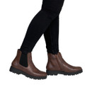 Model wearing chestnut brown Chelsea ankle boots with black elastic side panels, inside zip fastening and chunky tread soles, paired with black skinny jeans.