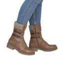 Model wearing Rieker women's tan lace-up ankle boots with knitted cuffs, side zips and chunky soles for stylish cold-weather wear.