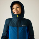 Child wearing a navy and blue hooded waterproof jacket with hood up.
